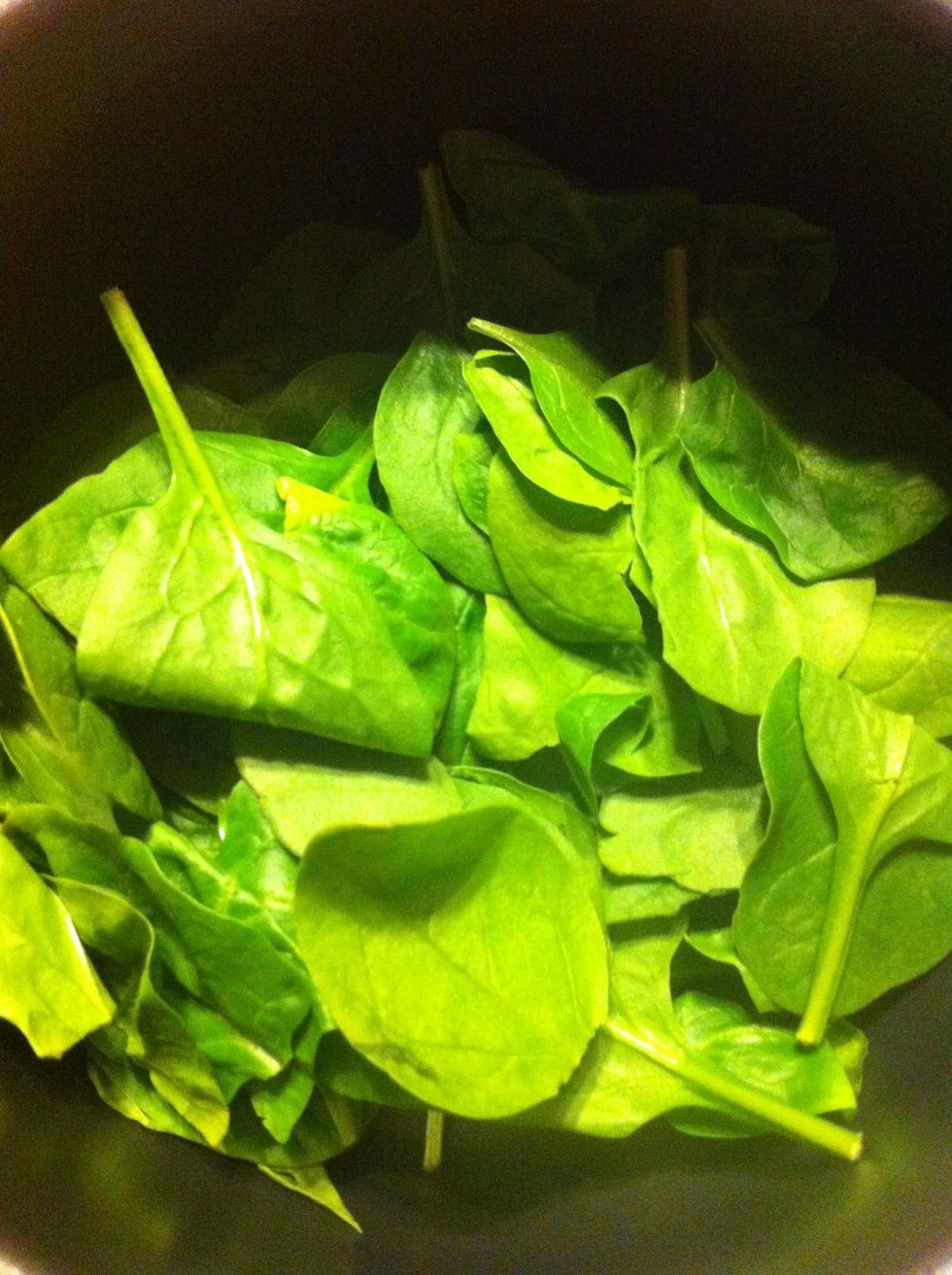 Take a nice had full or more of some spinach and plop it in a med size pot. Remember that spinach shrink up with heat and release it's own liquids so no need to add anything but your tons & onion