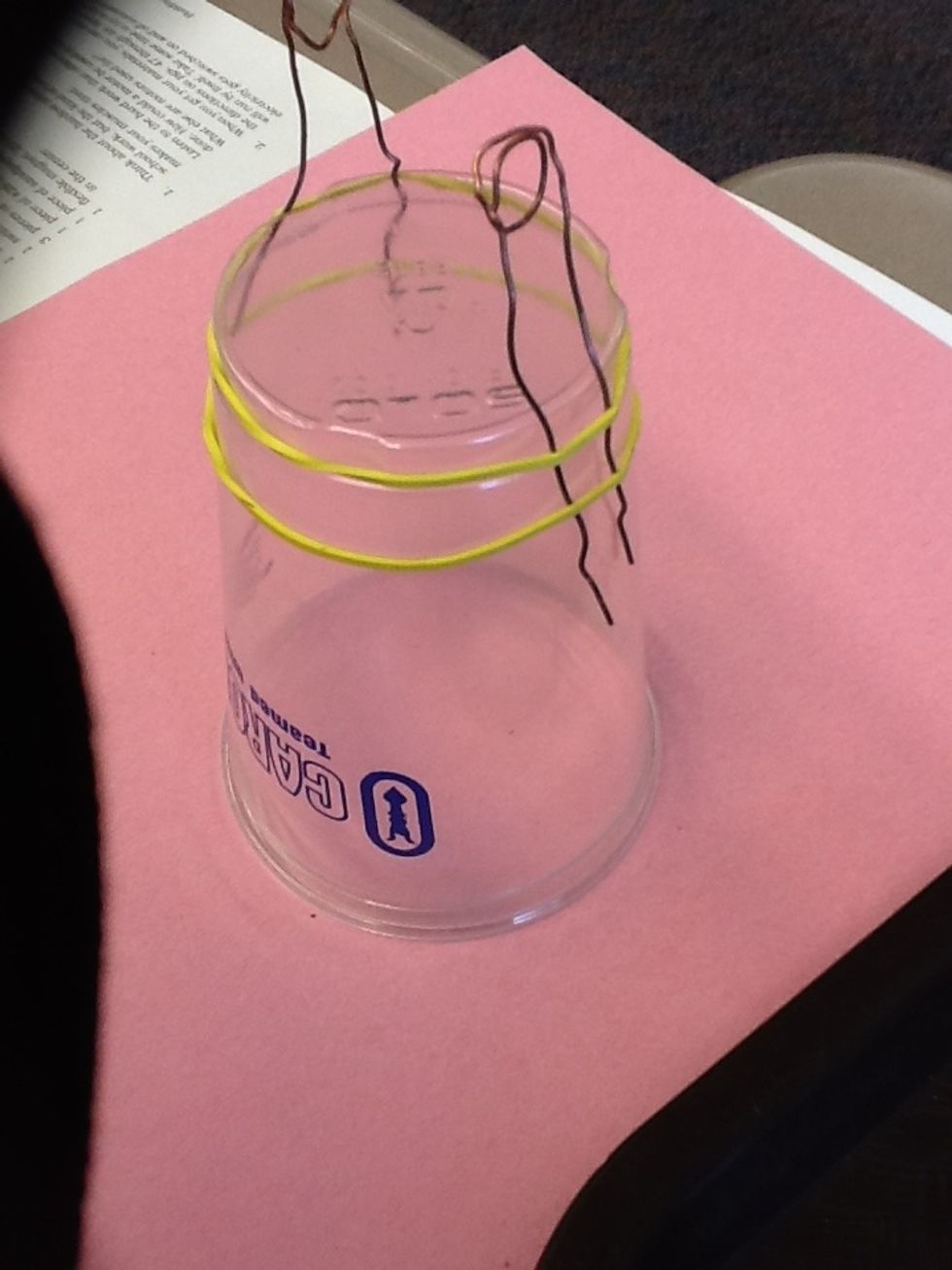 Take a pencil, marker, or the bolt (anything around that width), and wrap the middle of the bare copper wire around twice.