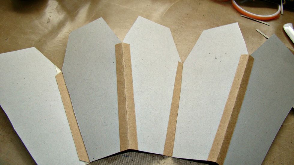 Take a piece of cardstock 1" wide and score down the middle to attach each coffin to each other as follows. Go ahead and create your mini album.