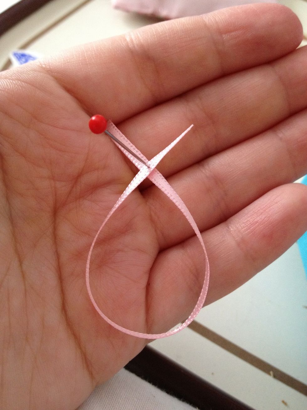 Take a piece of ribbon and cross over then pin
