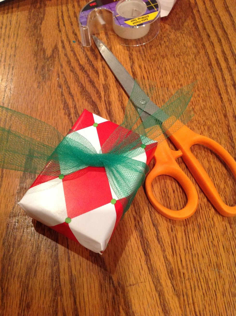 take a piece of tulle long enough so that you can wrap it around the present, tie a knot, and still have it long enough. The amount left sticking out will be about how big your bow will be.