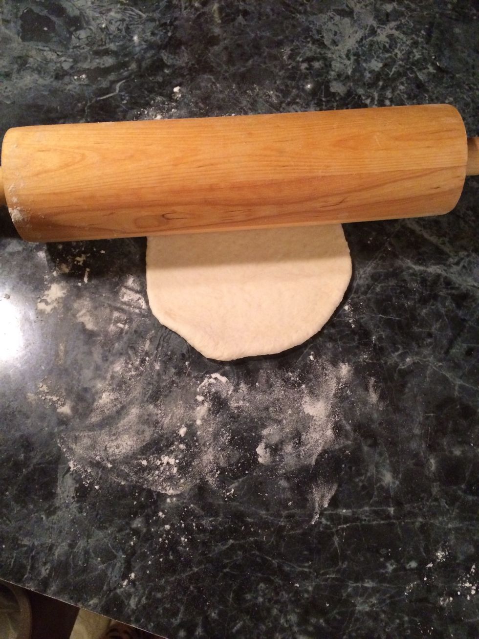 Take a rolling pin and start rolling out the dough as round as you possibly can and to 1/4" thickness.