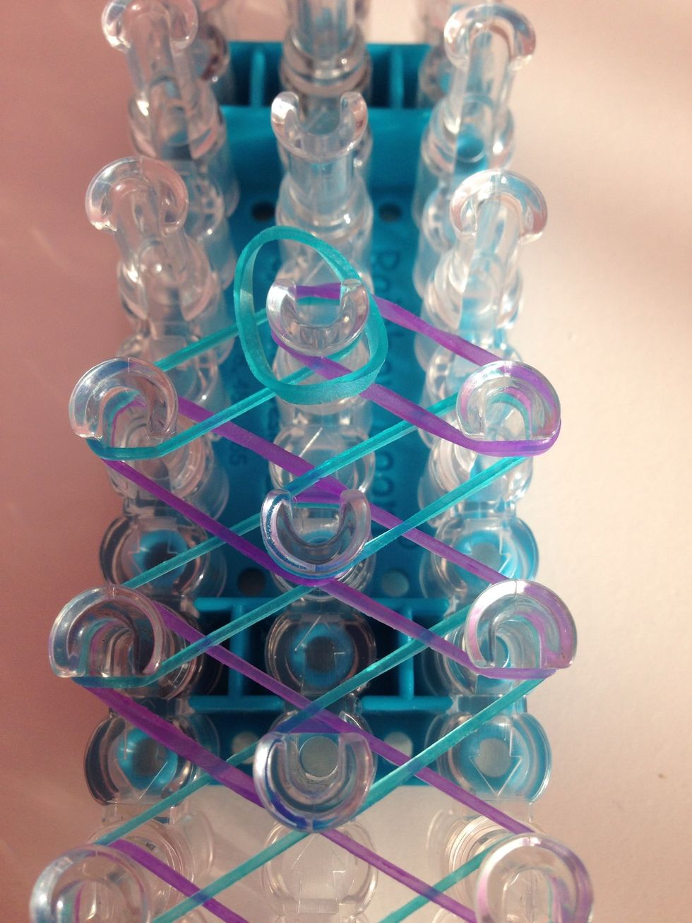 Take a rubber band and put it in the middle of the middle peg.