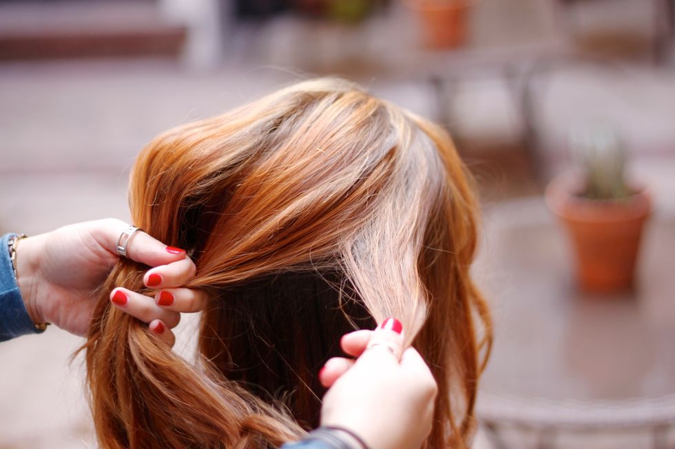 Take a section of hair from the top of the head. Divide it into two equal parts. Take a small amount from the outside of the right section.