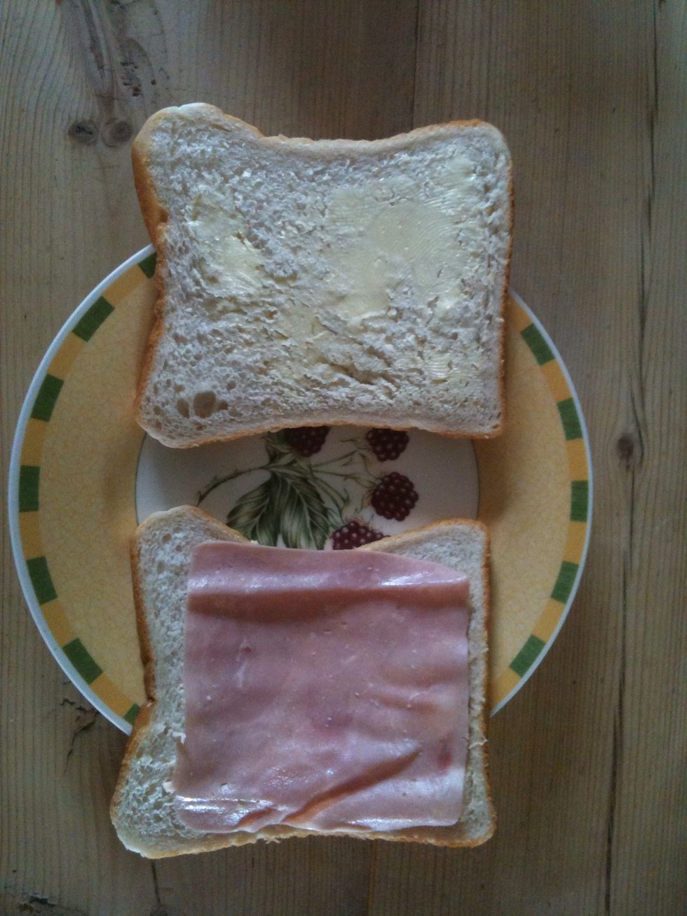 Take a slice of ham and lay it on one of the slices of bread