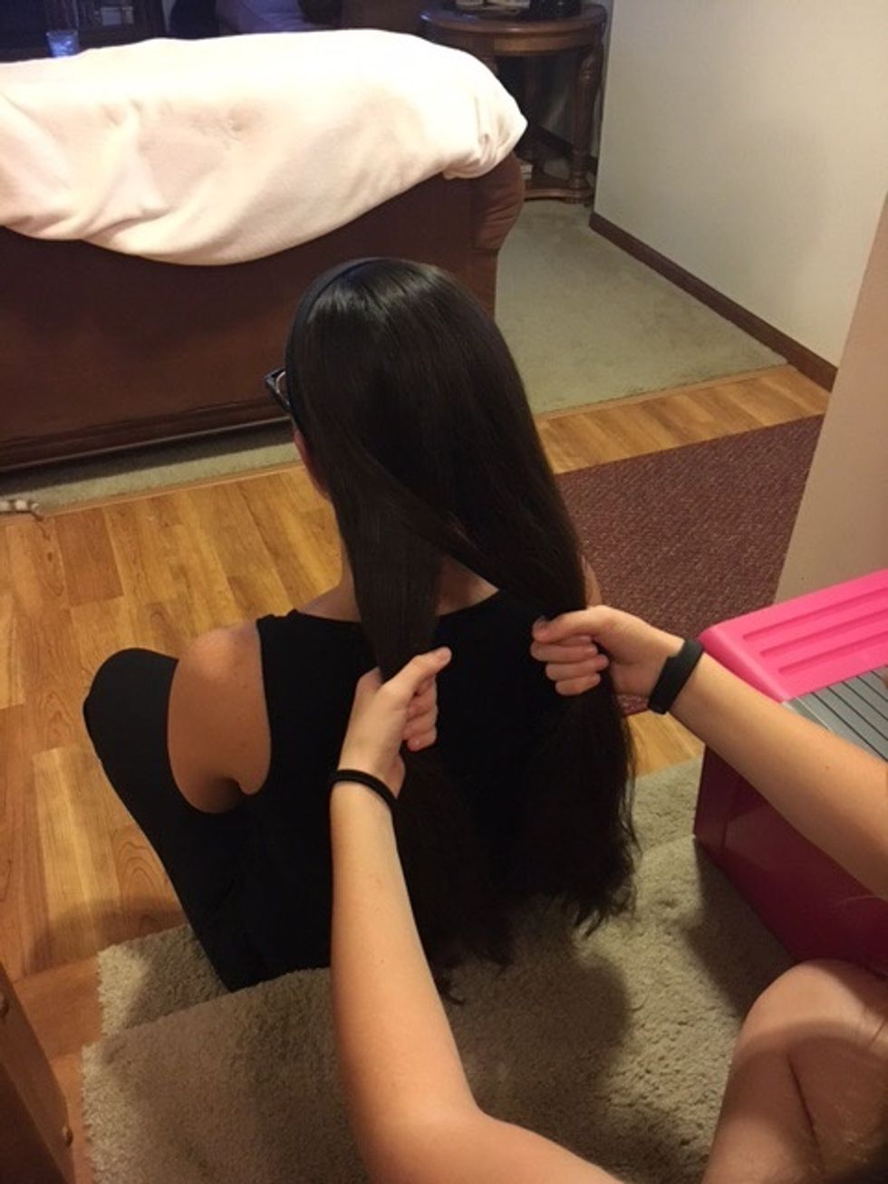 Take a small piece of hair from the far end of the right side and bring it over to the inside of the left half.