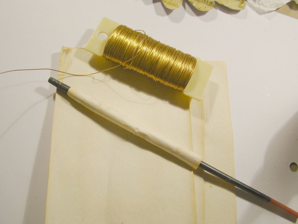 Take a small piece of paper (I had some old book paper) roll it around the handle of a paint brush, pencil etc. Cut a piece of metal wire and wrap it around your rolled paper.