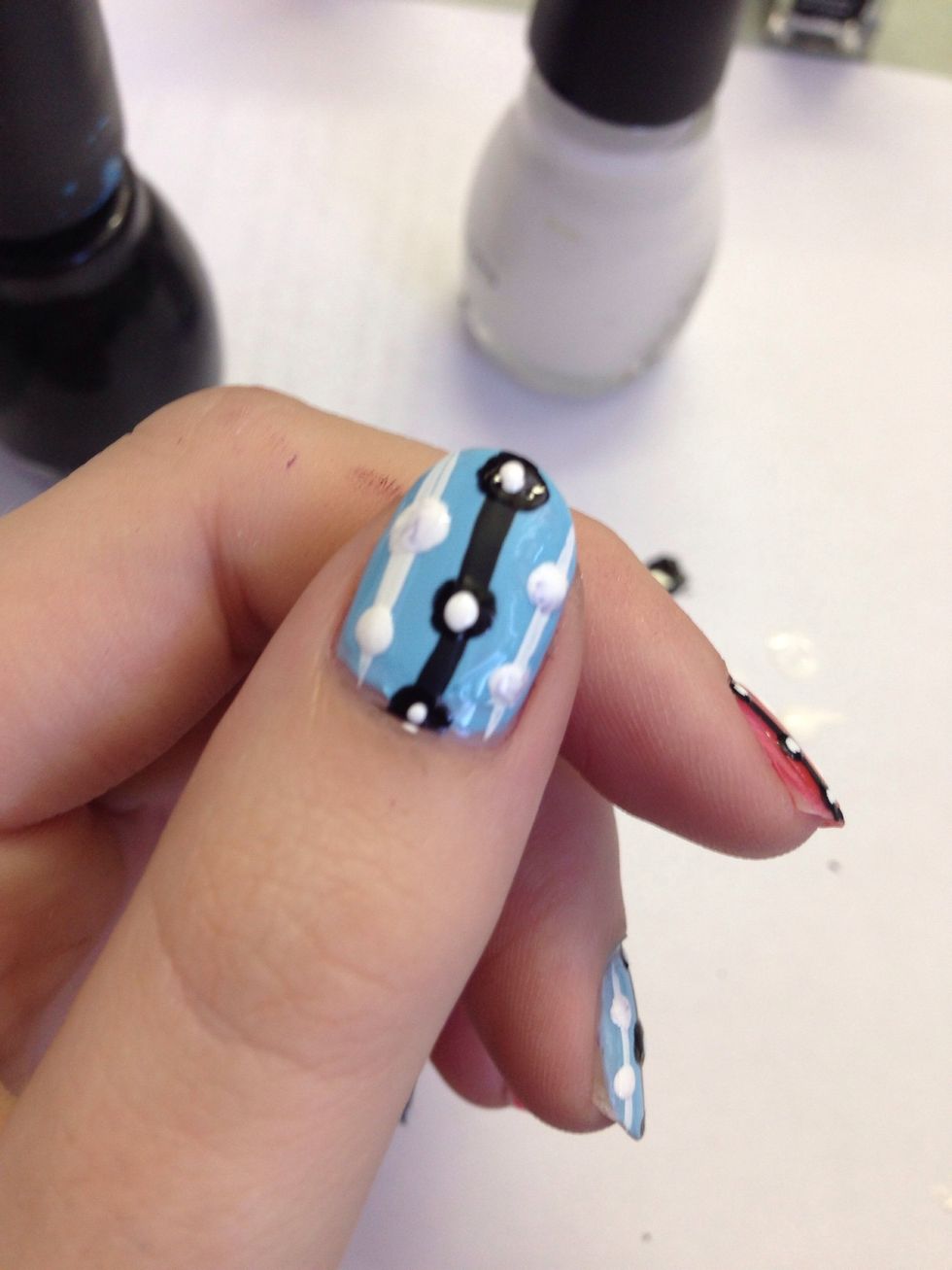 Take a smaller dotting tool and put a little dot of the opposite color into your original dots.
