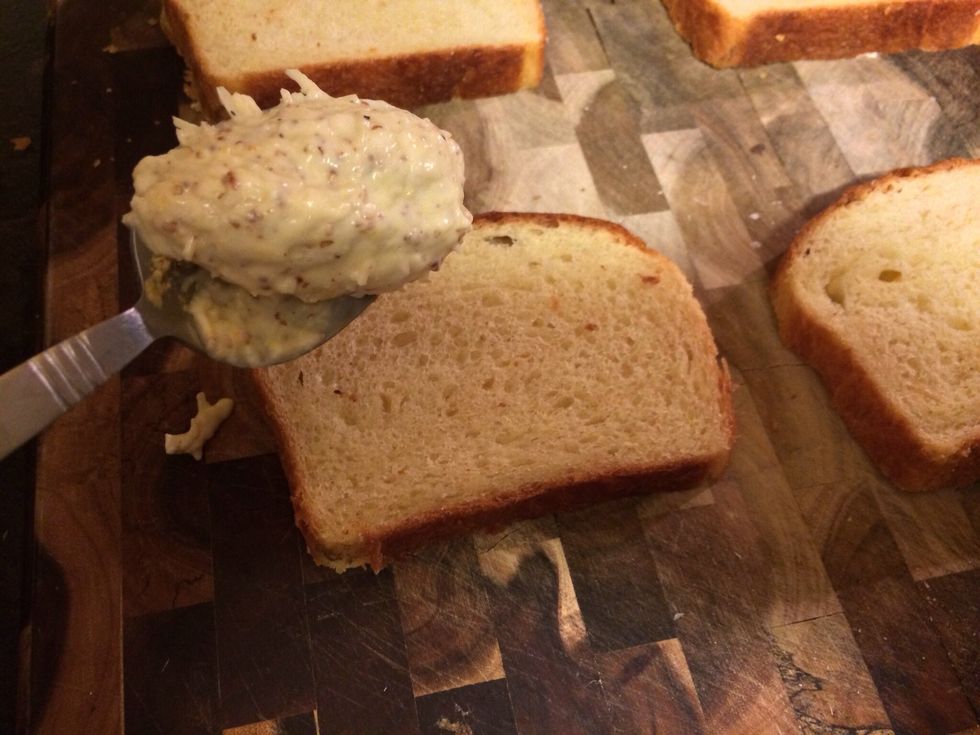 Take a spoon and start spreading the mayonnaise and mustard mixture over the bread. Don't skimp, and make sure all slices have this spread on top!