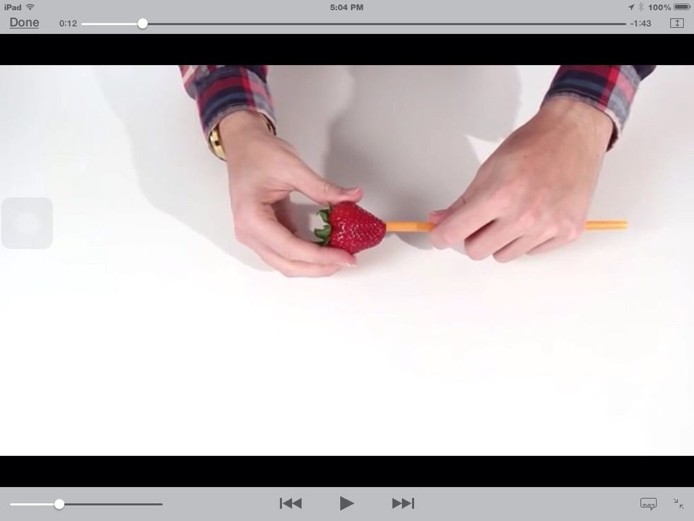 Take a straw and put it at the bottom of the strawberry