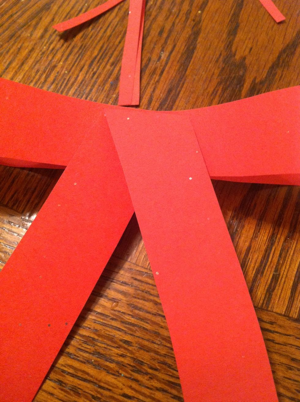 Take a third strip and fold it in half at an angle, glue it to the back of your bow where the two pieces come together.