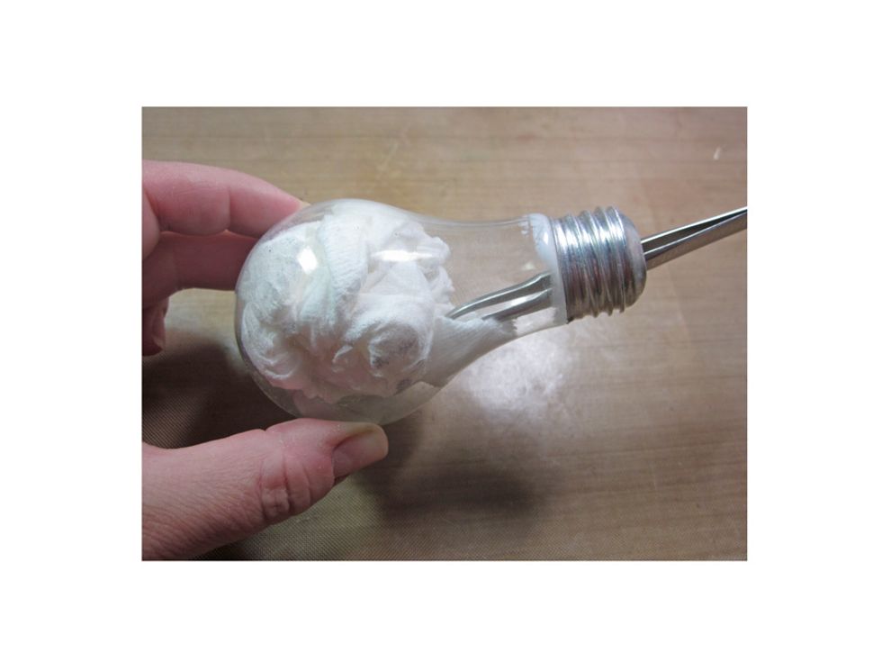 Take a tissue and run around the inside of the blub to remove the white powder layer. Be sure to wash your hands after this and don't get the powder near food or your mouth.