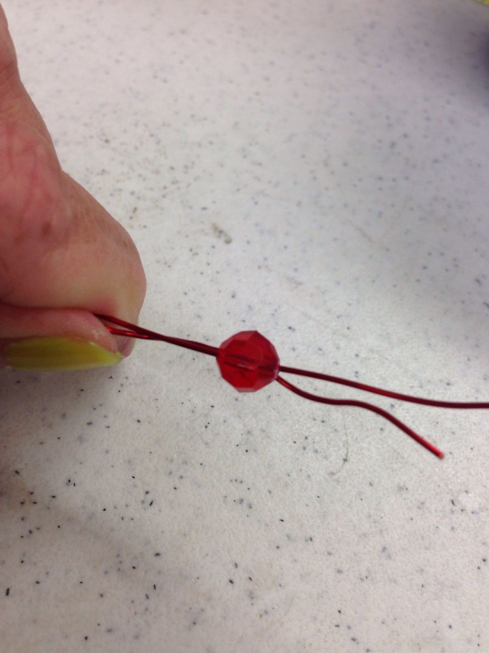 Take a wire from one bundle and one wire from the bundle next to it. Thread 1-2 beads onto the set of wires.