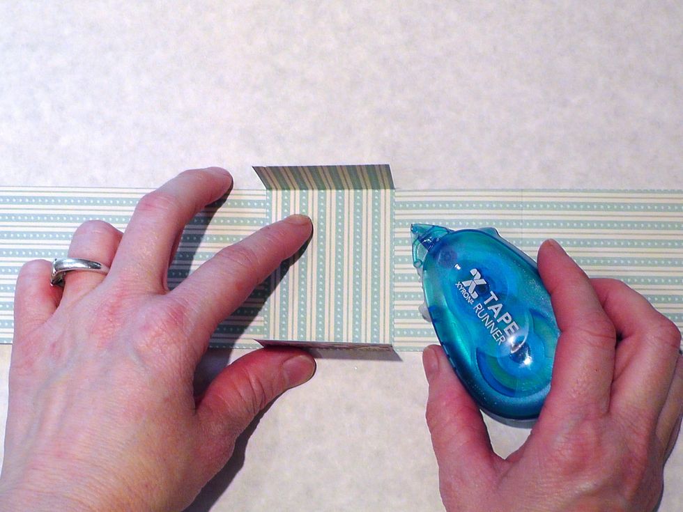 Take a Xyron tape runner and attach the smaller strip inside of the larger strip (you can use glue too)