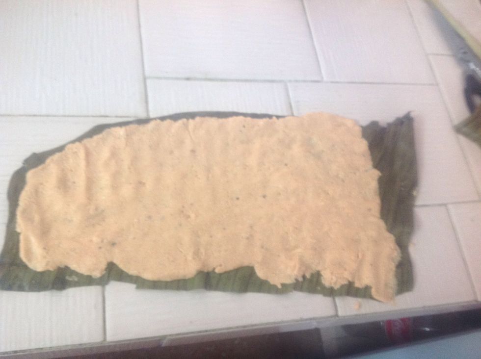 Take about 1/3 of remaining masa and spread as thinly as possible on a banana leaf as wide as the baking sheet. You will take this dough, turn the leaf upside down onto the filling to cover the pib.