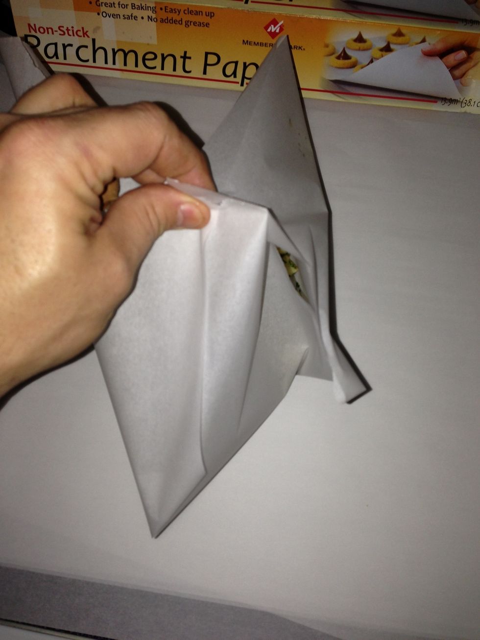 Take all 4 corners and pinch them together with one hand, then bring the "new" corners caused by the folds up as well.