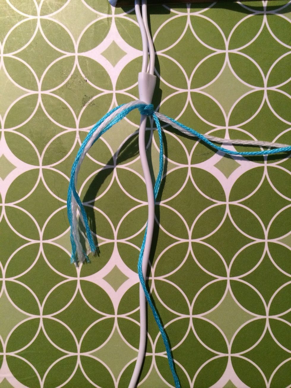 Take all of your string and make a knot at the very beginning of the cord. Leave a small tail. We will be knotting over this so it will hide the extra string and we won't have to use any glue.