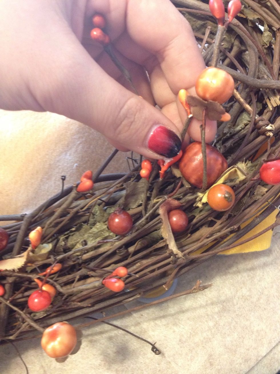 Take another garland branch and place on top of the first to follow around the wreath.