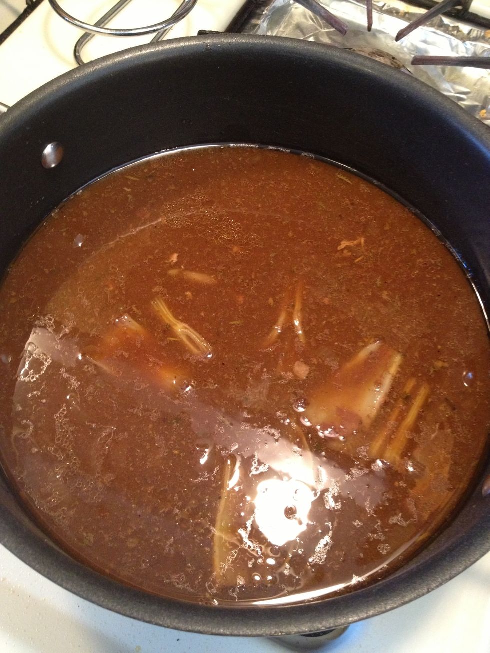 Take another pan, put it over the burners of the stove and let's add the juices from our slow cooker into it. Put the heat on medium.