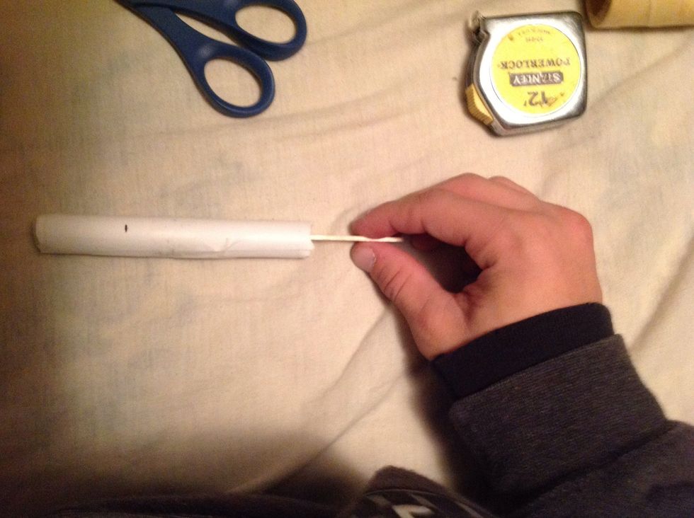 Take another popsicle stick and put in at the opposite end of your paper tube at a 90 degrees angle of the other popsicle stick at the other end of the tube.