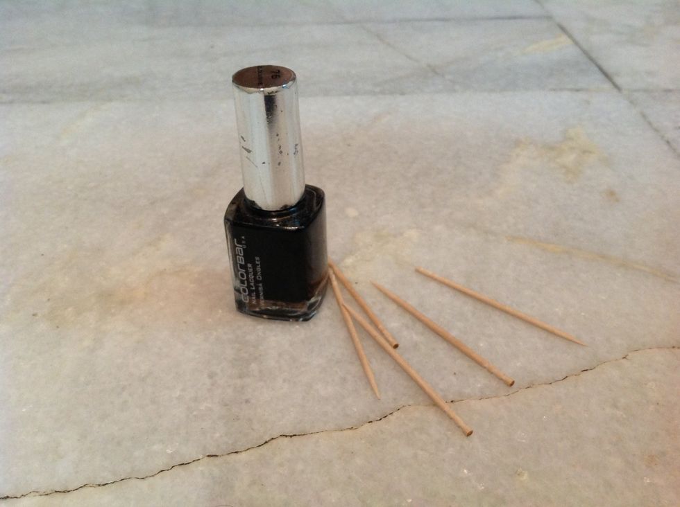 Take black polish and toothpick for giving it a perfect look.