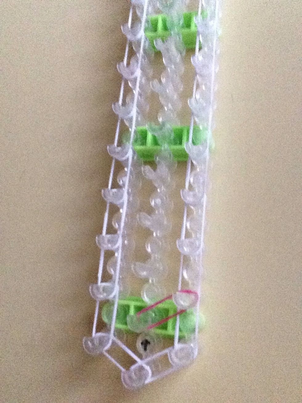 Take color #1 and put it on the peg in front of the arrow and stretch it the the peg on the top right.