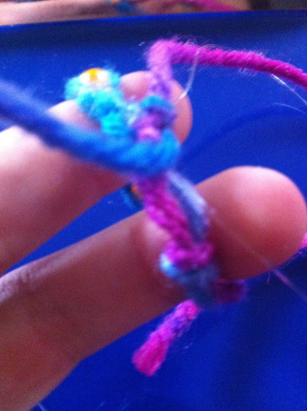 Take half of the strings and put them though the loop then tie 3 knots.
