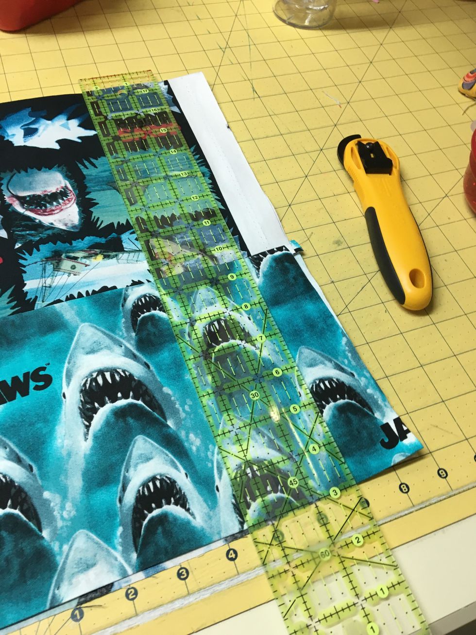 Take it to the cutting table, straighten both sides, cutting off the selvedges, I folded it just to make it easier to cut. Do the same for the bottom edge.