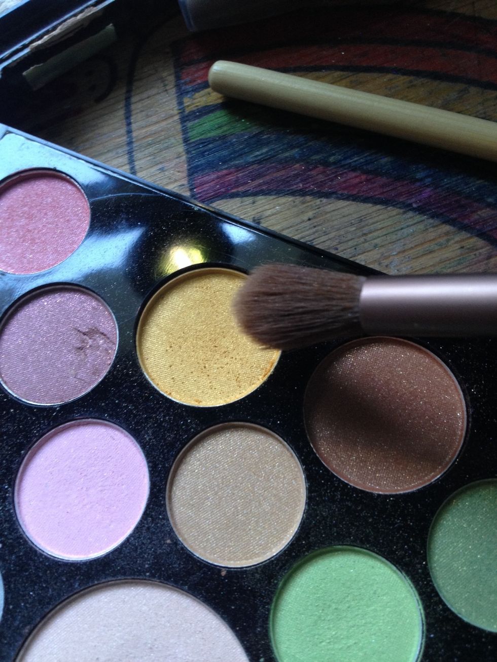 Take light orange eyeshadow on a fluffy blending brush.