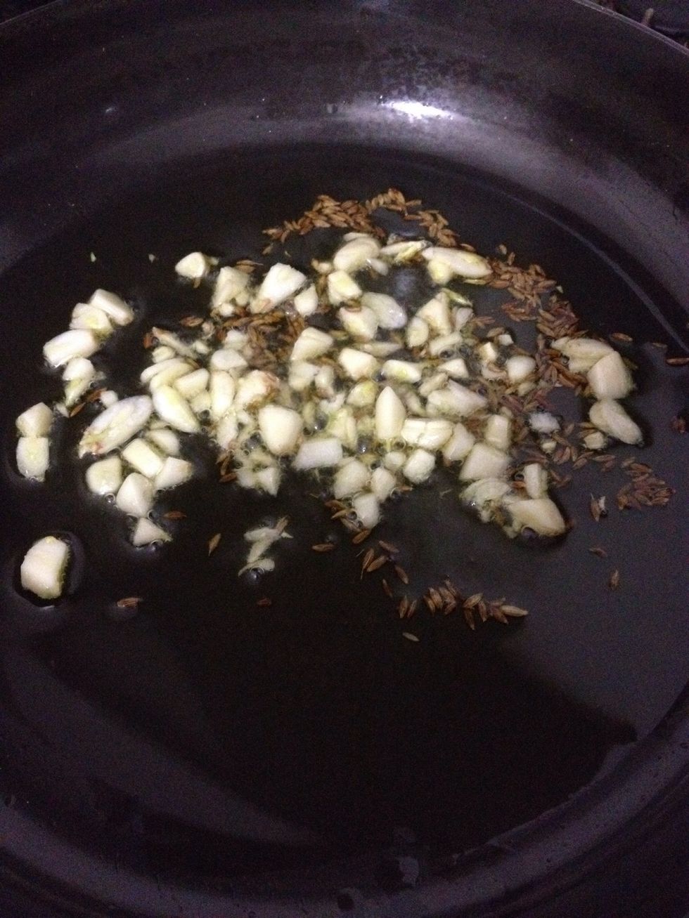 Take olive oil in pan add cumin and garlic. Fry them for a minute on low heat
