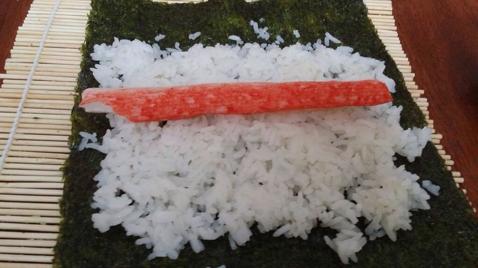 Take one imitation crab leg, and place it in the exact center of the rice/seaweed.