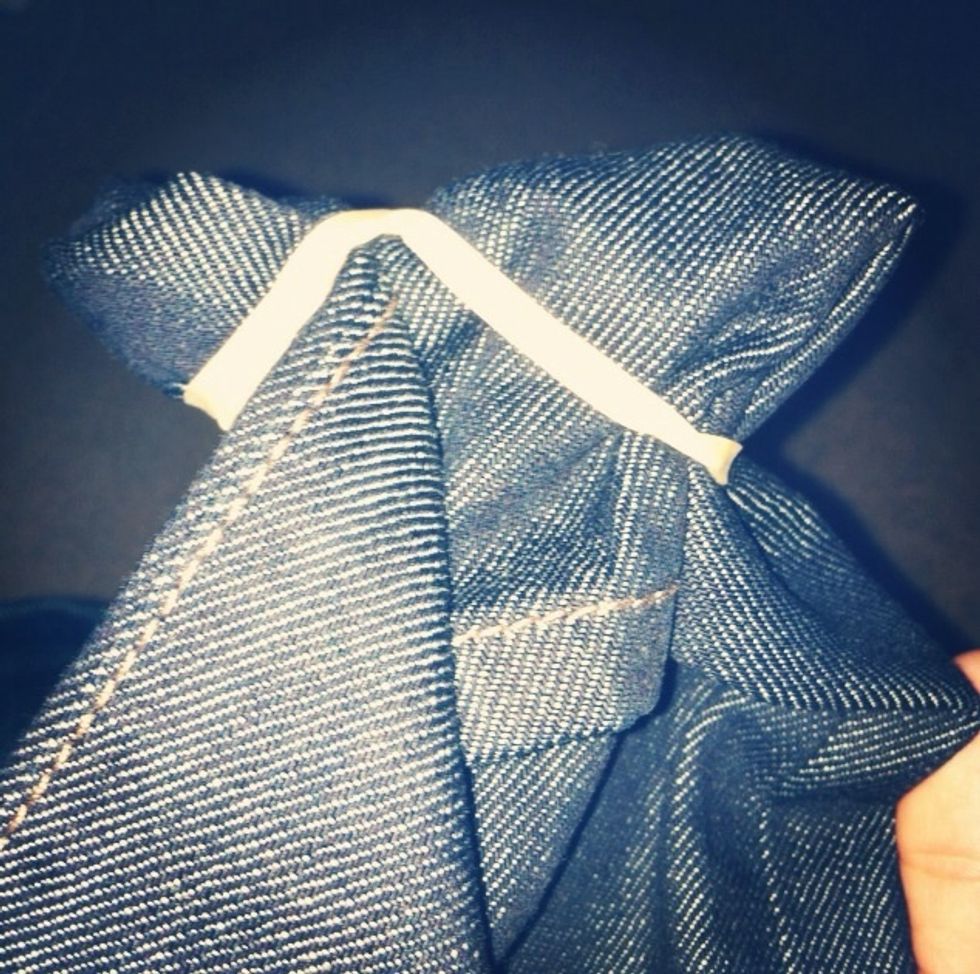 Take one leg and begin making tiny folds starting from the bottom, working your way up. Wrap the rubber-bands randomly around the jean as you twist and scrunch the jean.