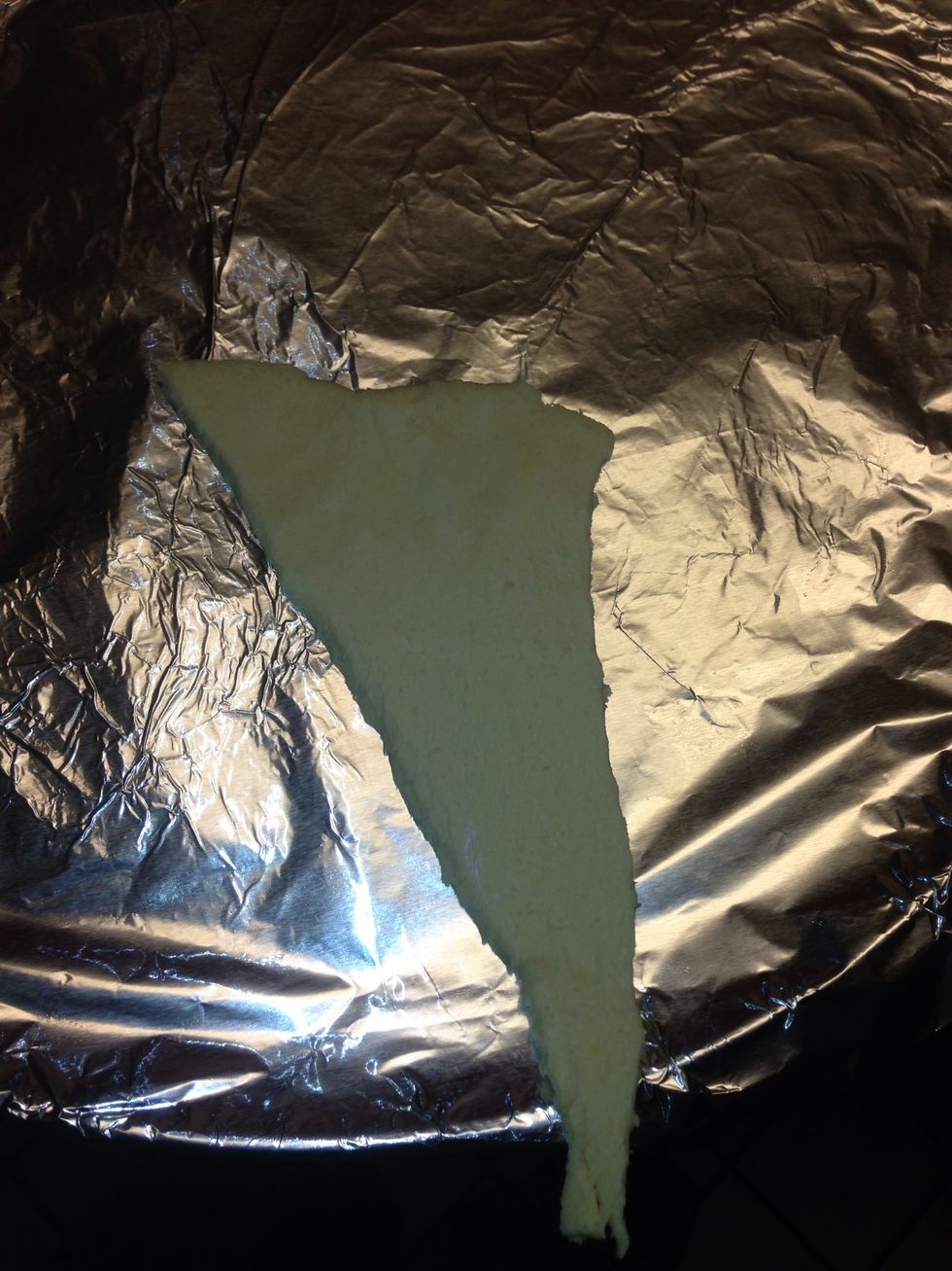 Take one piece of crossaint roll and lay the wider side down and hang the smaller side off the side if pan as pictured above. Press the fatter side down and to the side.