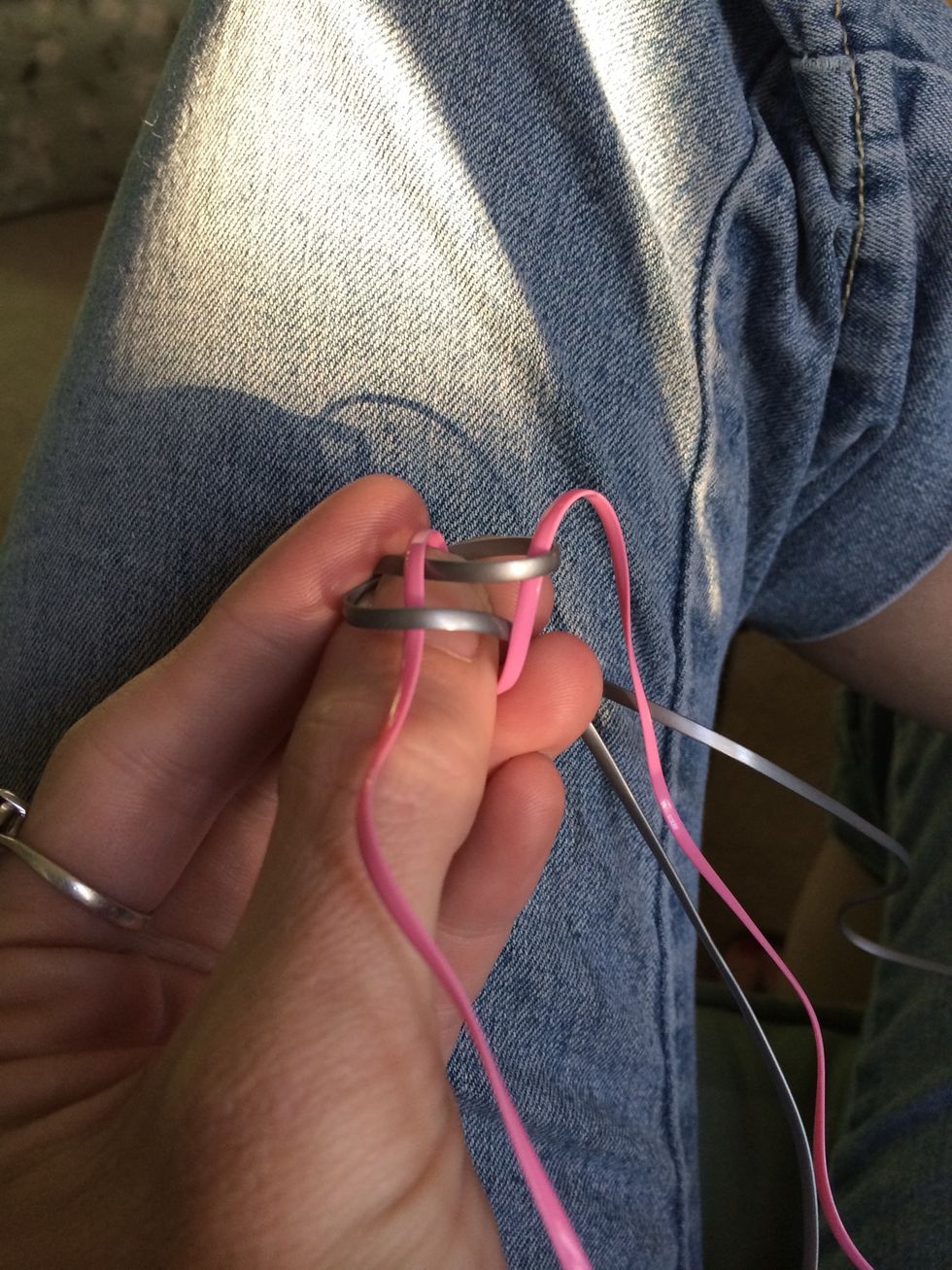 Take one pink lace and go over the first silver loop and under the second. Take the other pink lace and do the same thing. Over the first loop and under the second loop.