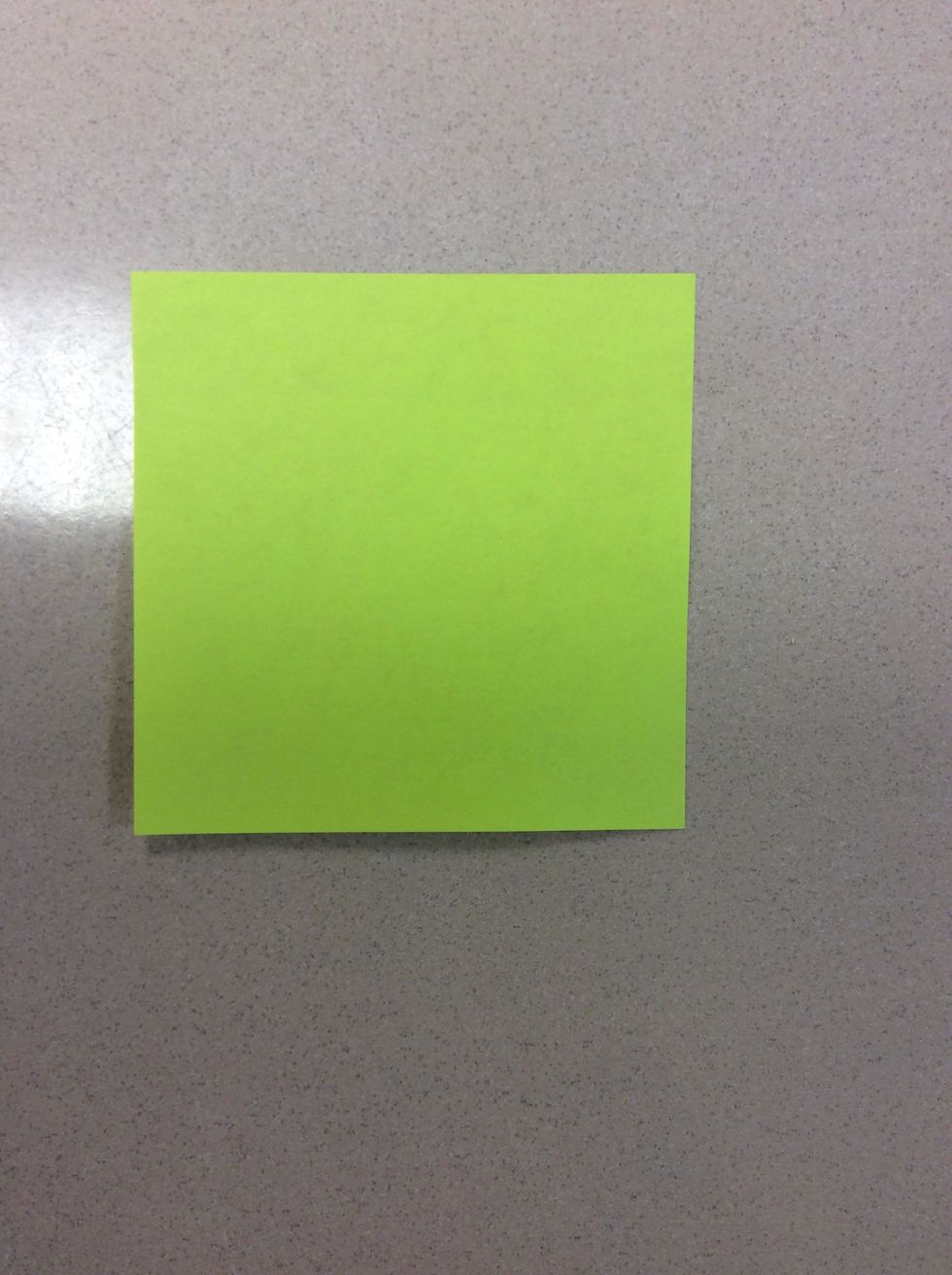 Take one Post-It note, and lay the sticky side on the table or flat surface facing up.