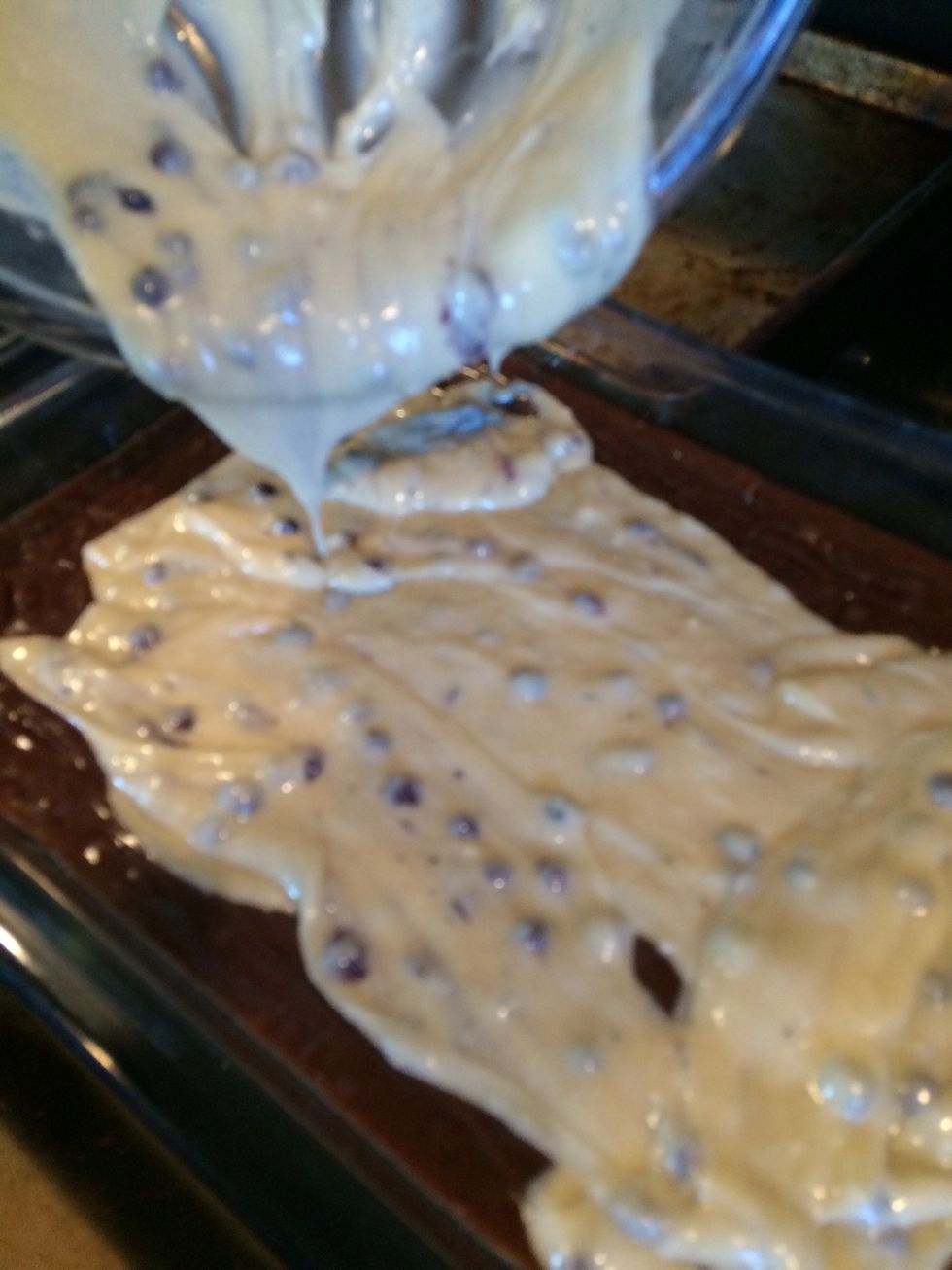 Take out the brownies after 10 minutes. Pour the blueberry muffin mix over the brownies. You will not be able to smooth out the mix, so spread the mix as you pour / spoon it out of the bowl.