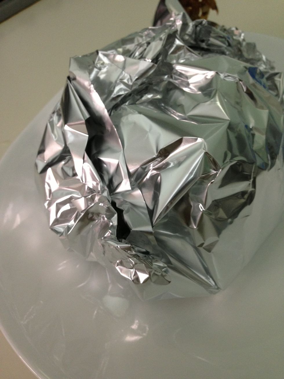 Take out the casserole from the oven. Take the chicken out and wrap it with an aluminum foil so that it continues to cook