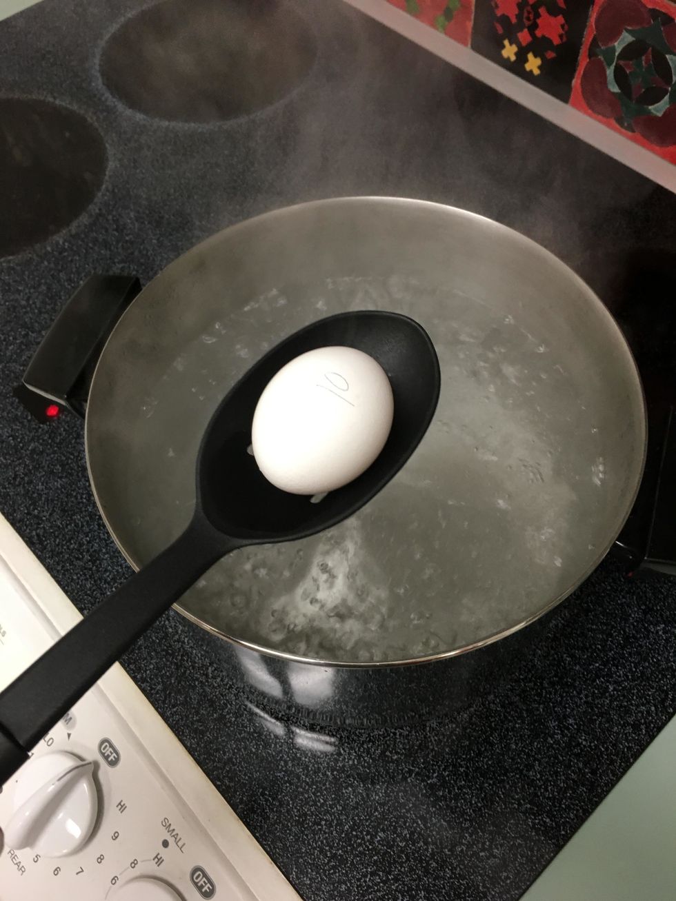 Take out the eggs from the sock. Then, place the eggs in to the boiling water with a slotted spoon very slowly, being careful not to drop the eggs in and break them.