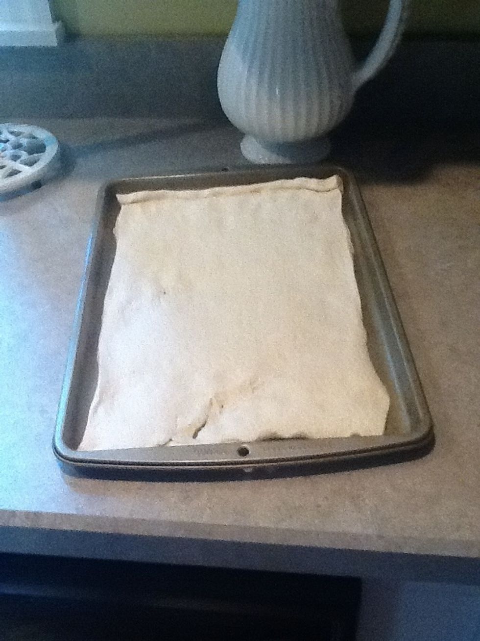 Take out your dough and spread it across the pan evenly.