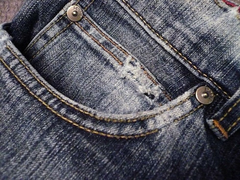 take paper towel or kitchen wipe and pour some bleach on, not too much. start wiping the jeans where you want them lighter. proceed slow to see the effect. where fabric is broken it should be lighter.