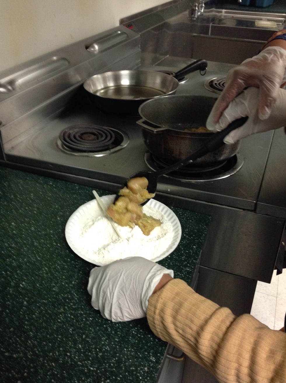 Take seasoned chicken and cover it in flour