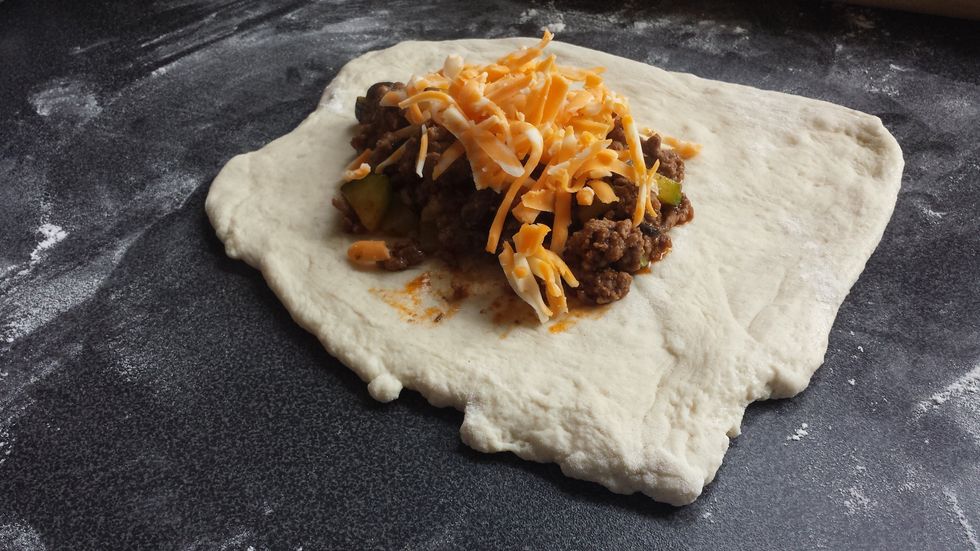 Take serving spoon and take spoon full of meat and place on dough after take 3/4 of a tablespoon of cheese and place on top of meat!