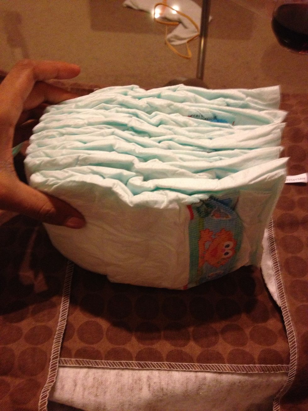 Take six diapers and line them straight and secure with rubber band. .