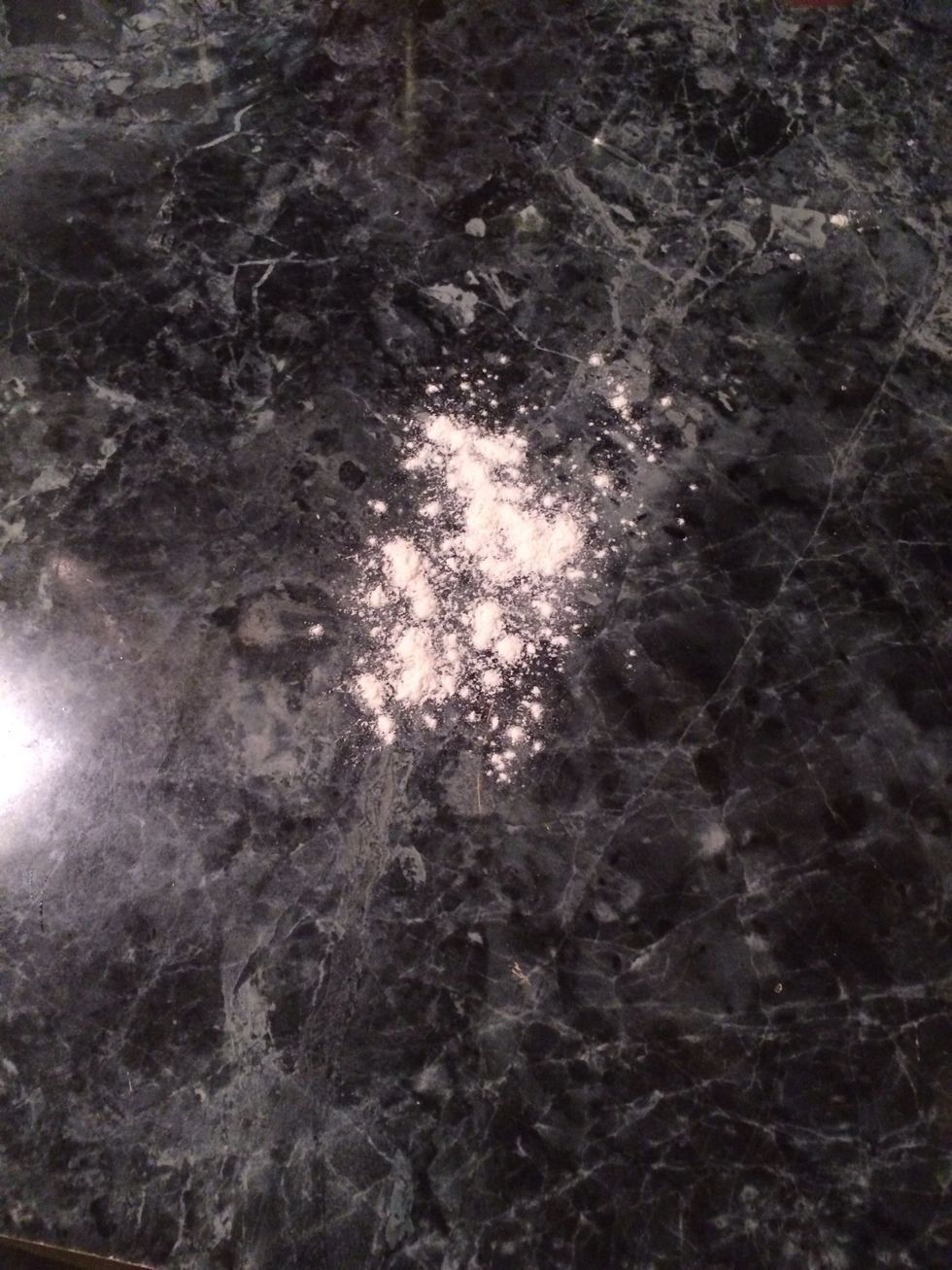 Take some flour and put it on a flat surface.