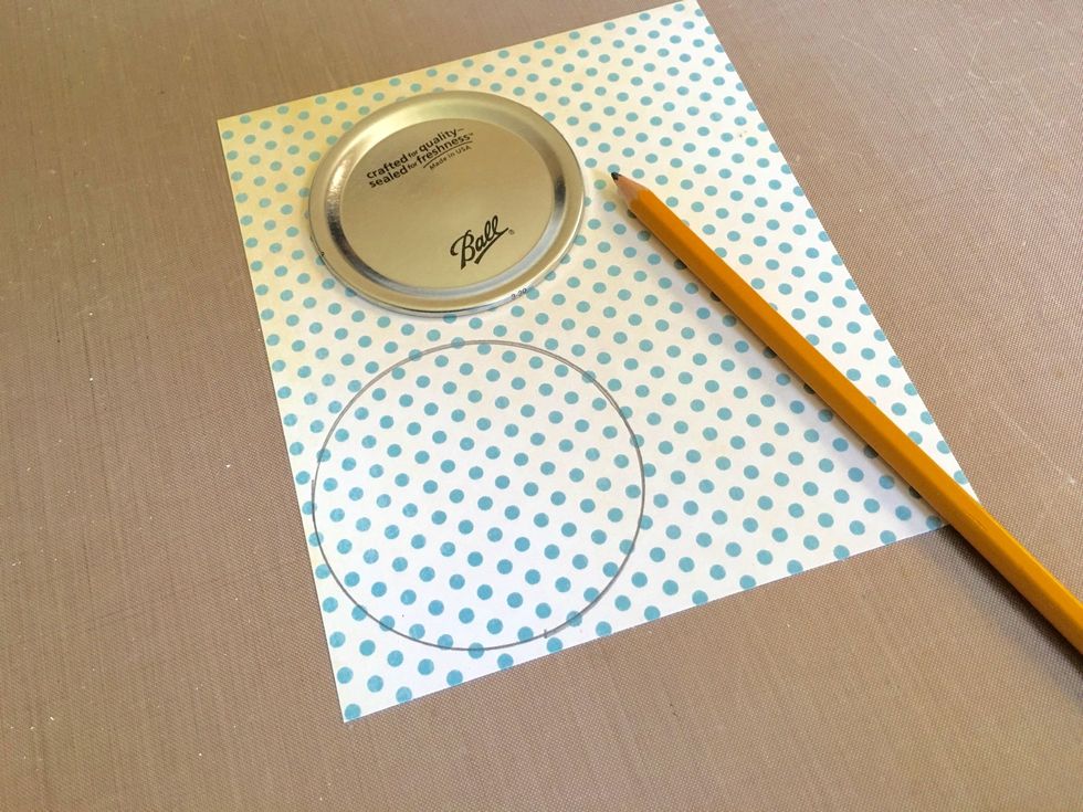 Take some G45 Botanical Tea paper and the center of the mason jar lid and use a pencil to trace it onto the design paper. We'll be cutting these circles out and inserting them back into the lids.