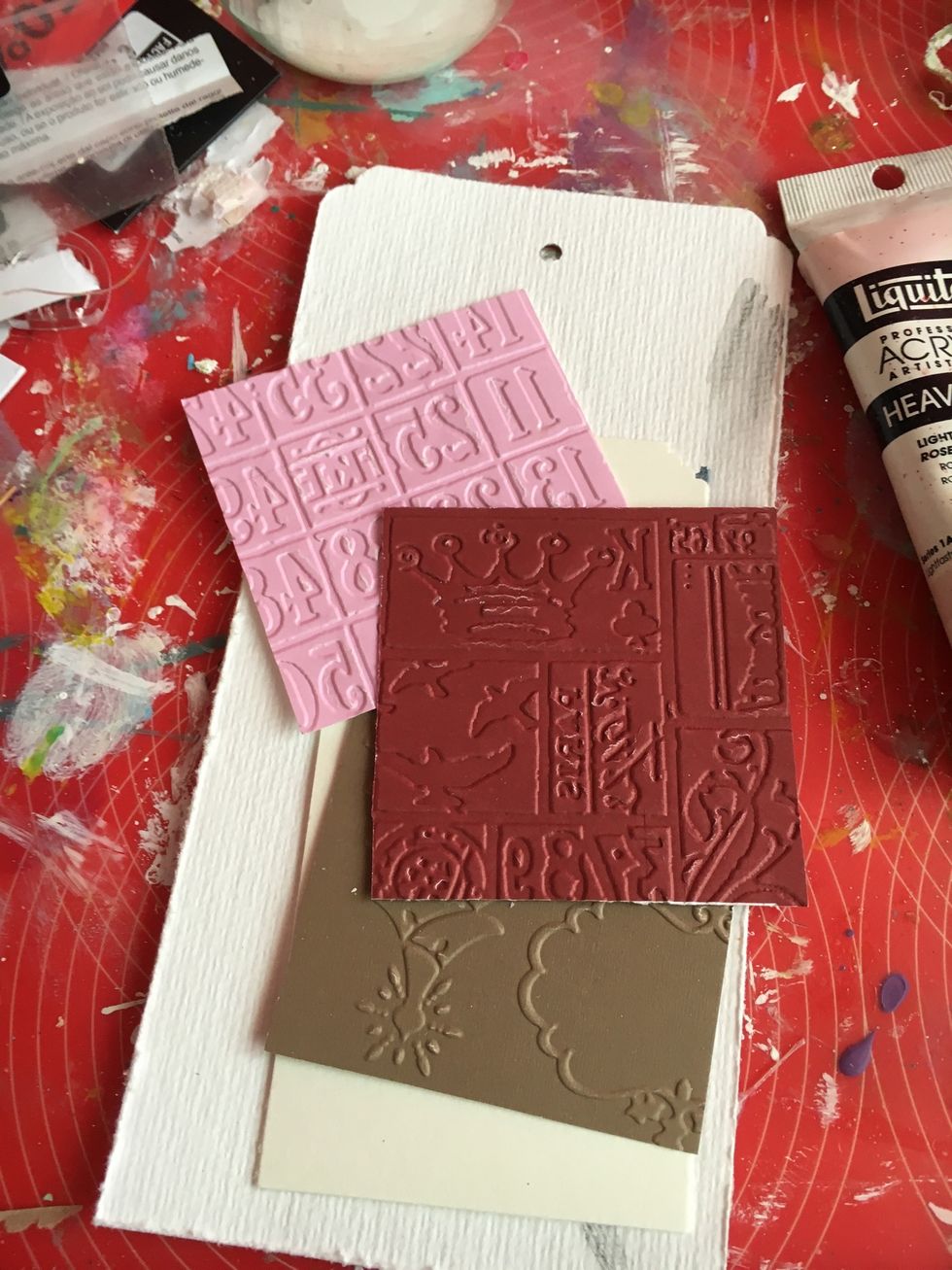 Take some pieces of embossed papers and cut for create your texture