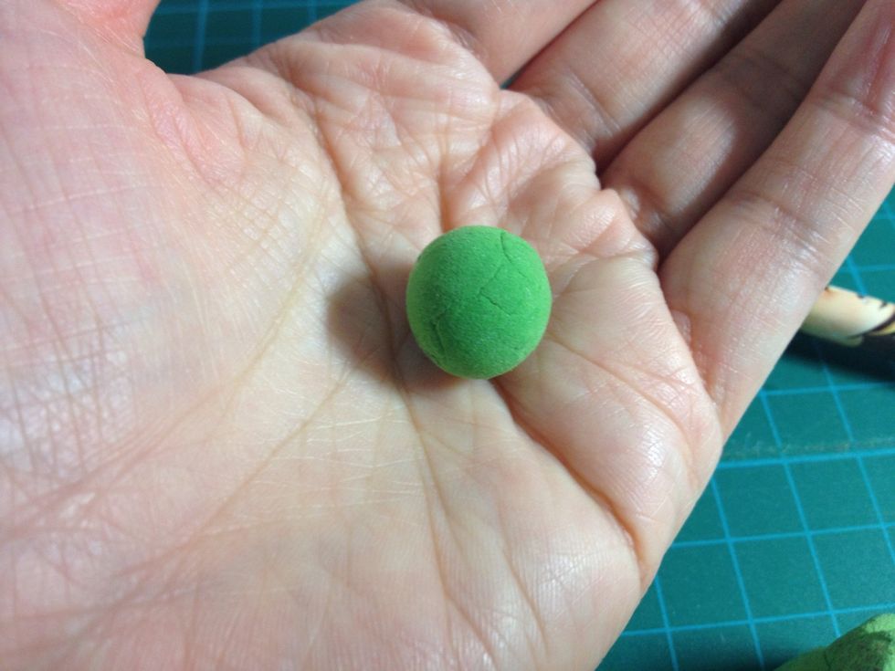 - Take some the green clay and roll on hands to become a ball shape.