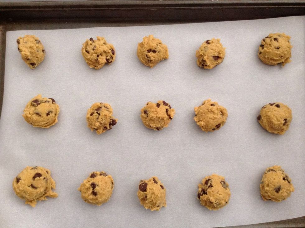 Take tablespoon sized pieces of the cookie dough and roll them up into balls. (You are doing this on the wax paper)