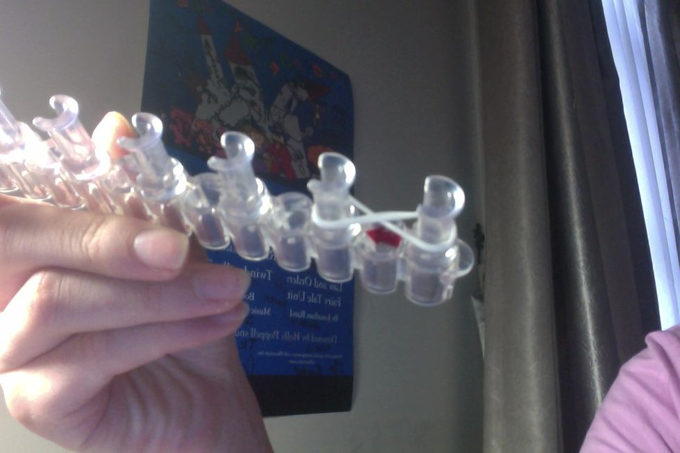 Take the '8' rubber band and put it on your 2 pegs.