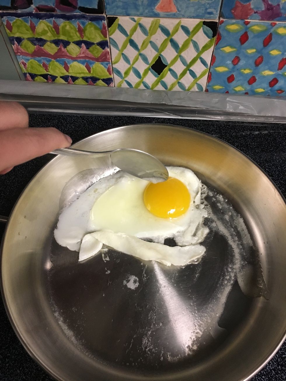 Take the access butter around the pan and with a spoon and place it on top of the egg